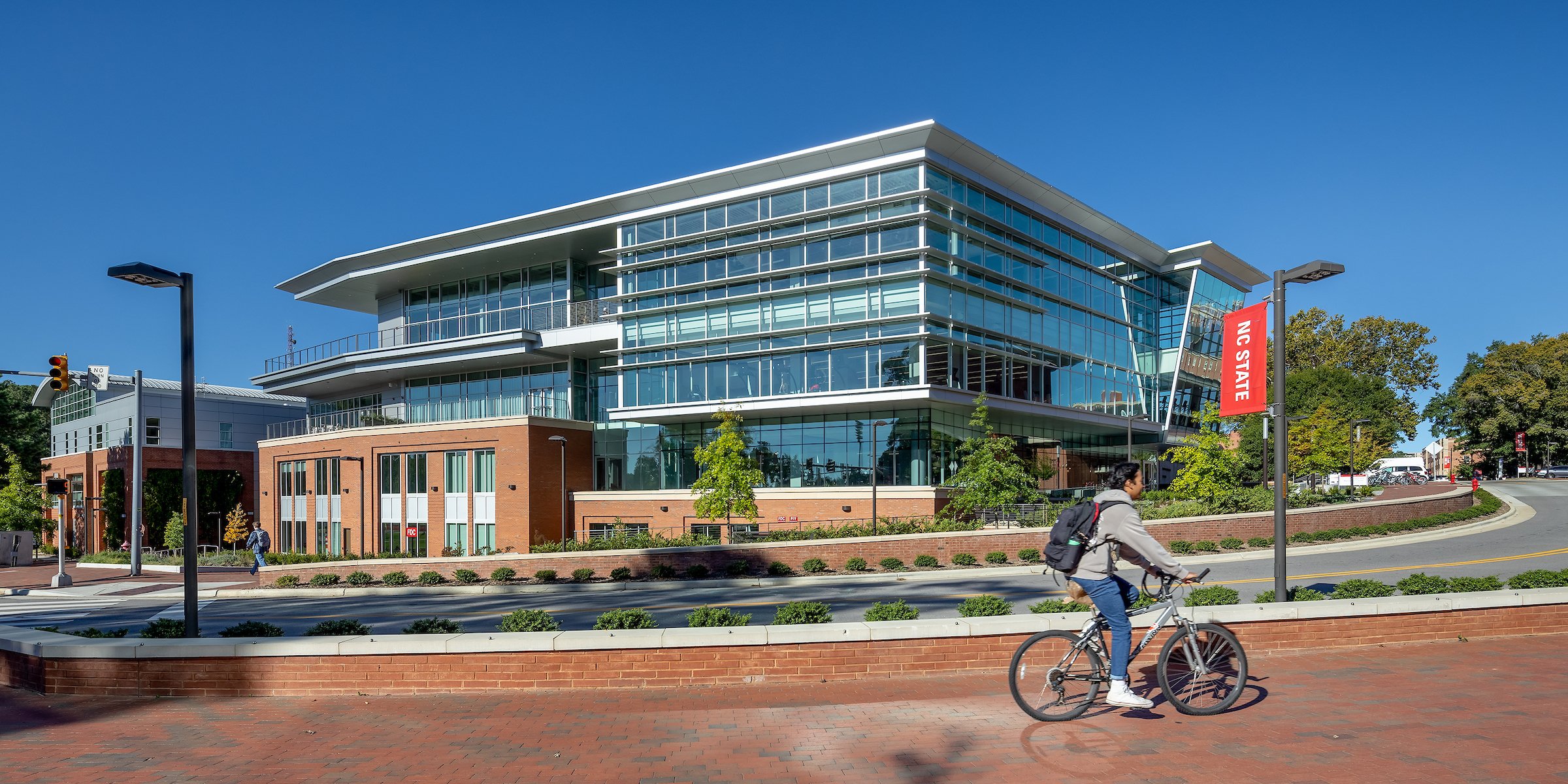 student riding bike past the Wellness and Recreation Center