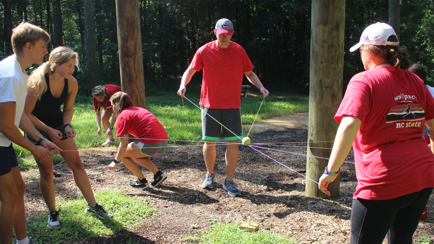 group participating in a low ropes course activitiy
