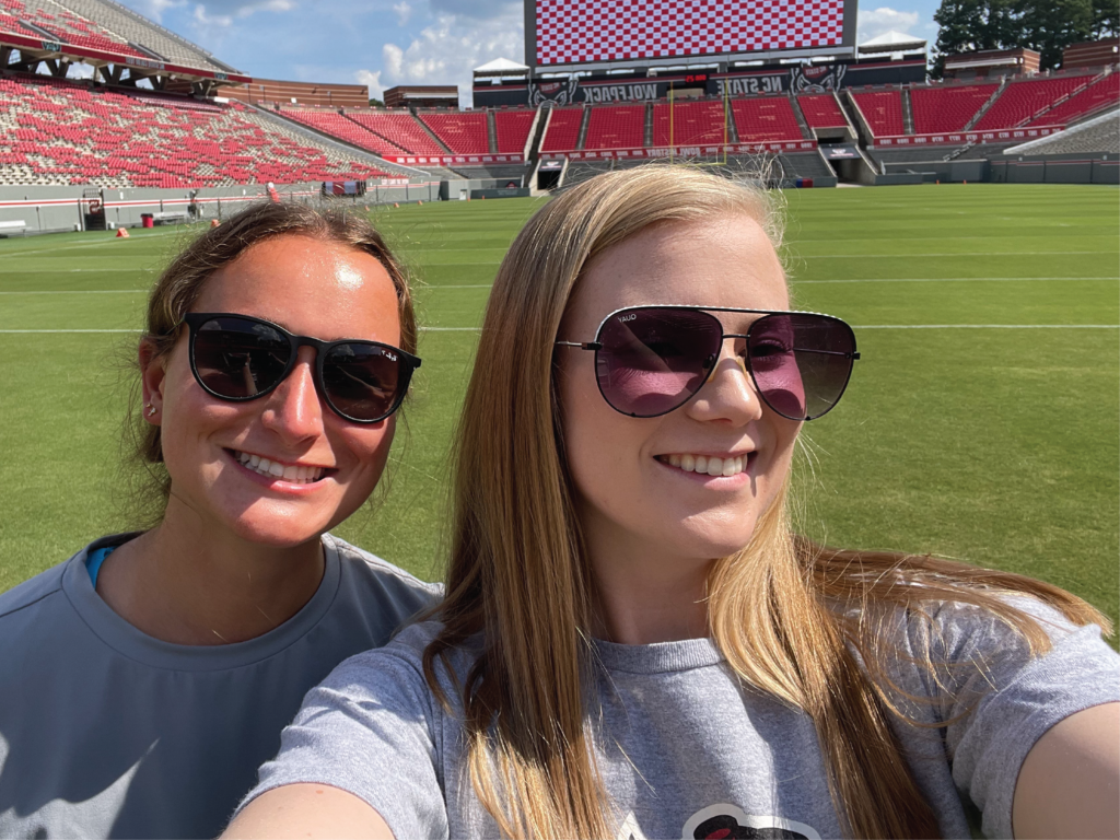 Kaylyn Poole and a friend taking a selfie on the NC State football field
