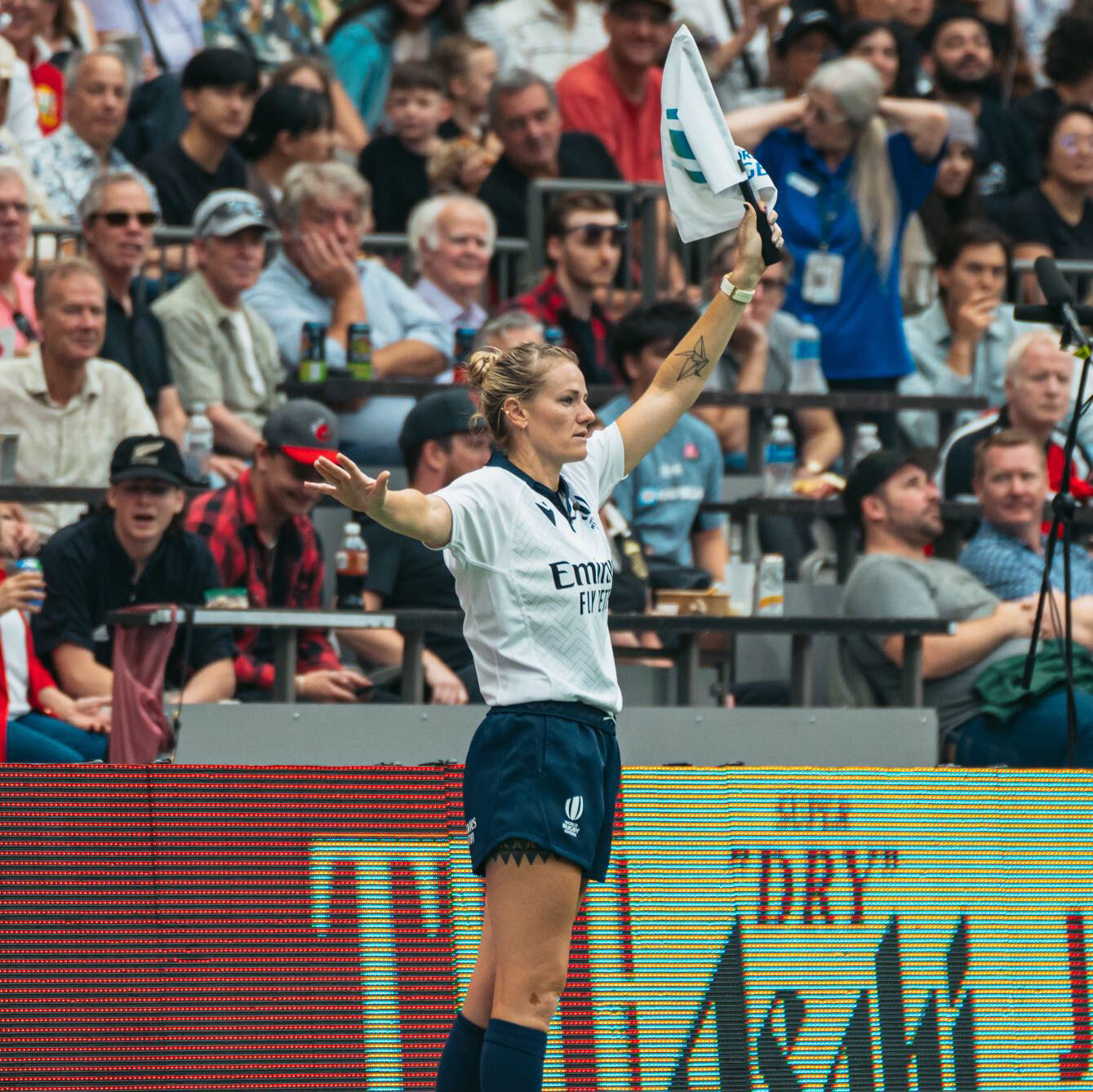 Kat Roche holding up a referee flag