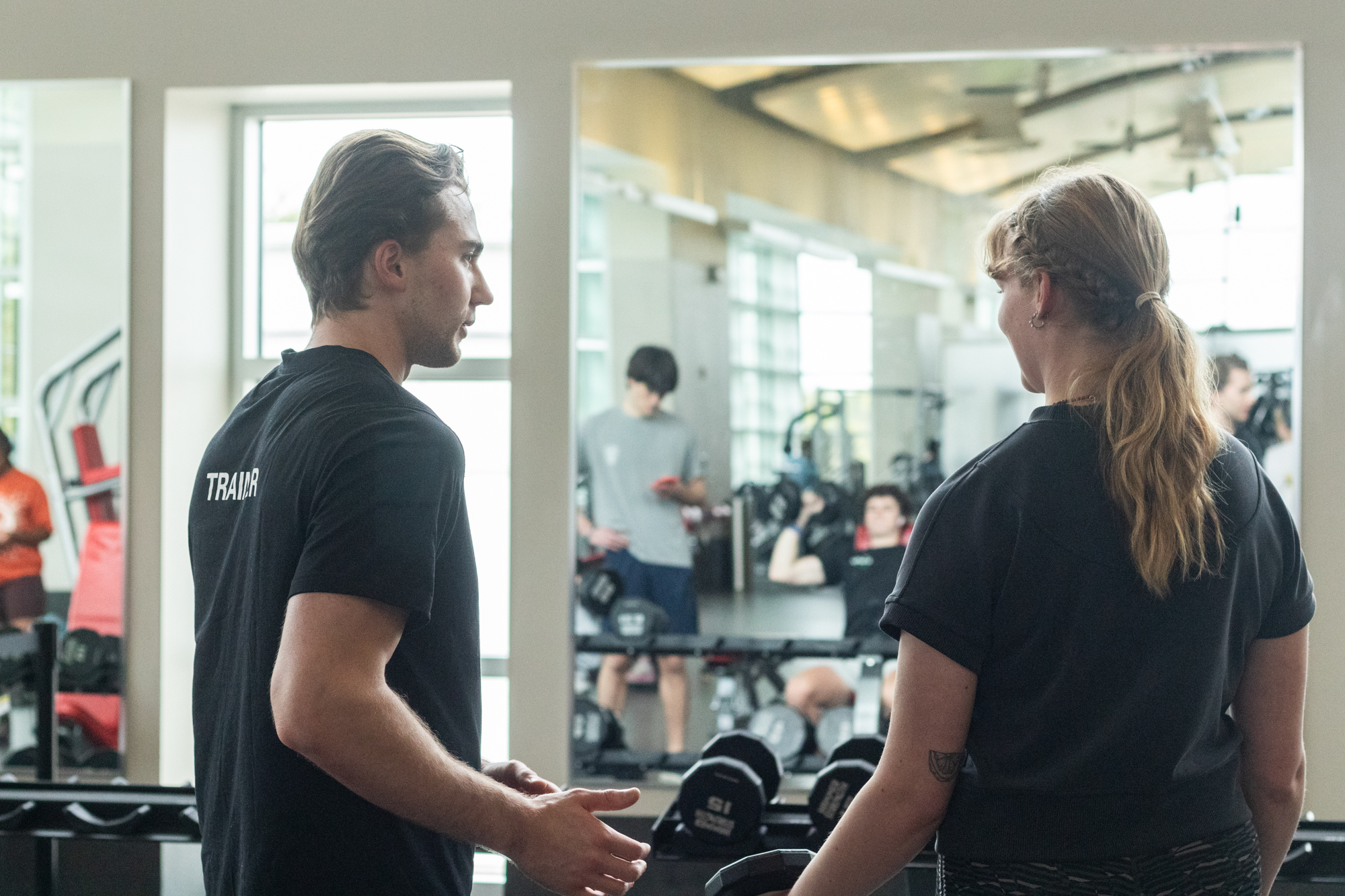 a personal trainer working with a client on squats