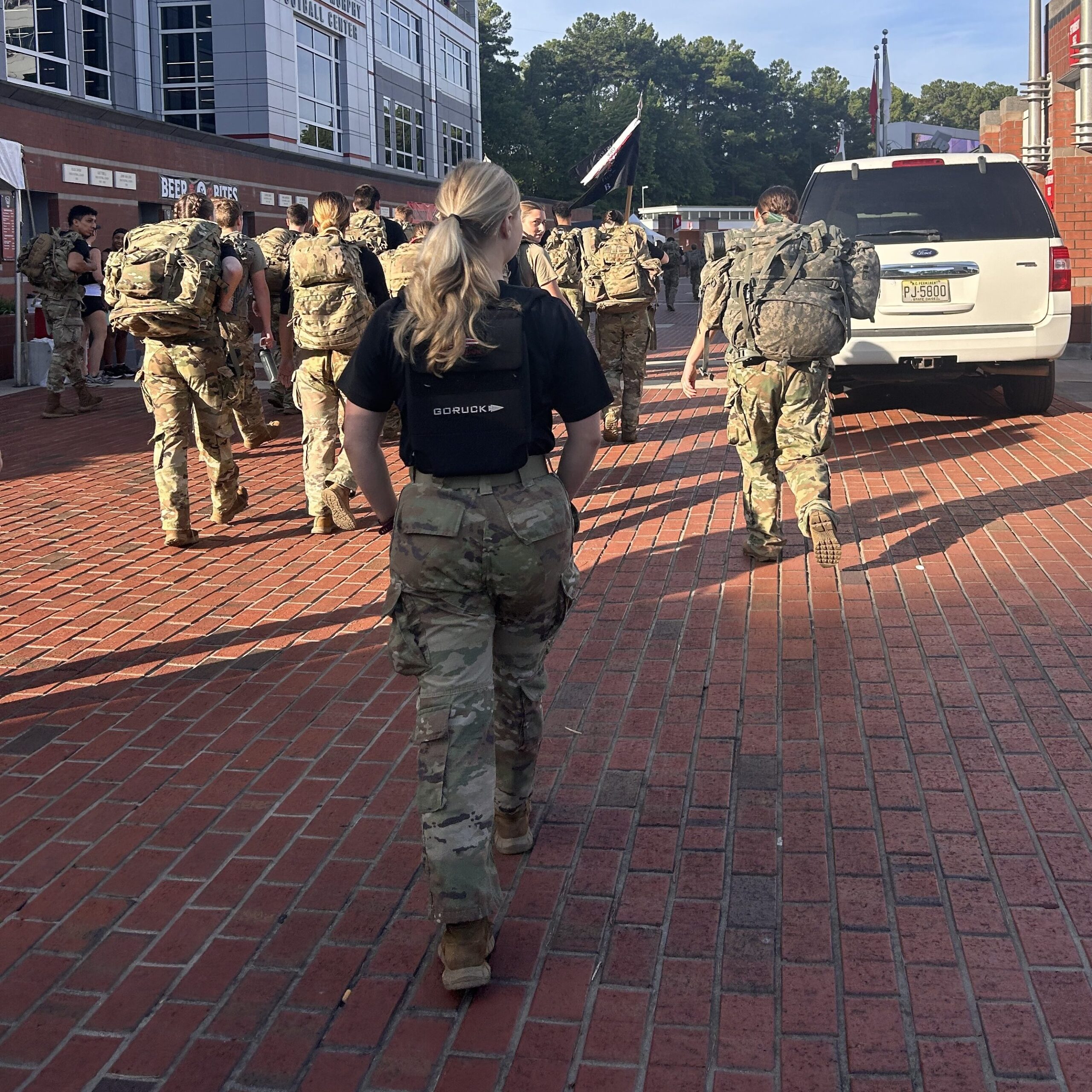 Becca Strong walking away from the camera in a military uniform